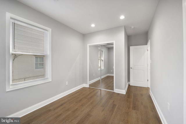 unfurnished bedroom featuring dark hardwood / wood-style flooring and a closet