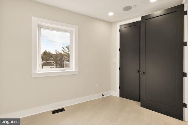 unfurnished bedroom featuring a closet and light wood-type flooring