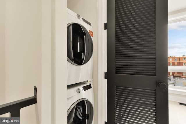 clothes washing area with a wealth of natural light and stacked washing maching and dryer