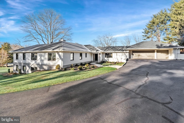 ranch-style home featuring a front lawn and a garage