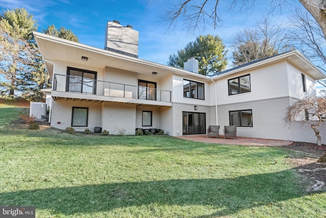 rear view of house featuring a balcony, a yard, cooling unit, and a patio