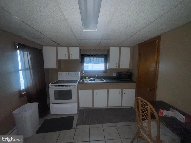 kitchen with white cabinets, a drop ceiling, white electric range, and sink