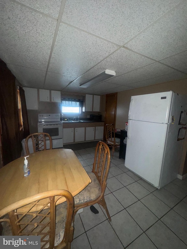 tiled dining room with a paneled ceiling