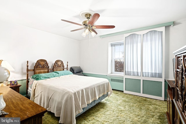 bedroom with carpet flooring, radiator, and ceiling fan