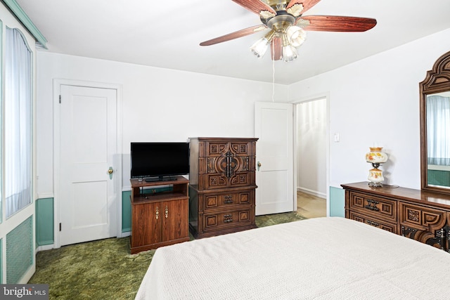 bedroom with ceiling fan and dark carpet