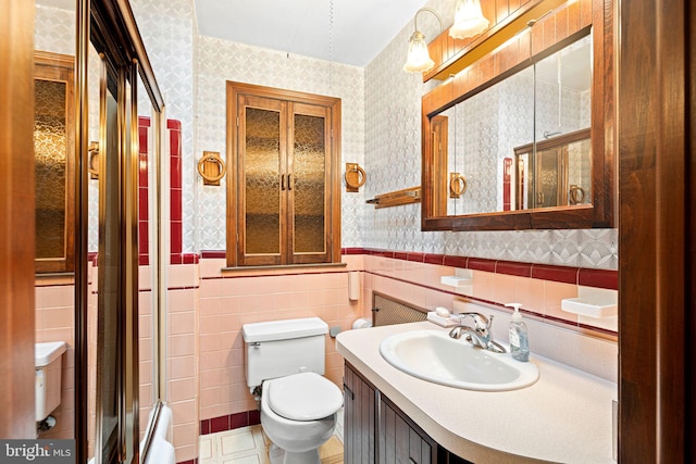 bathroom featuring vanity, toilet, and tile walls