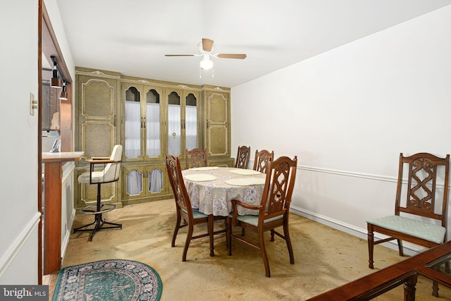 carpeted dining room featuring ceiling fan