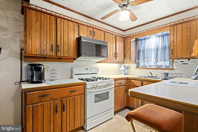 kitchen featuring ceiling fan, white range with gas cooktop, ornamental molding, and sink