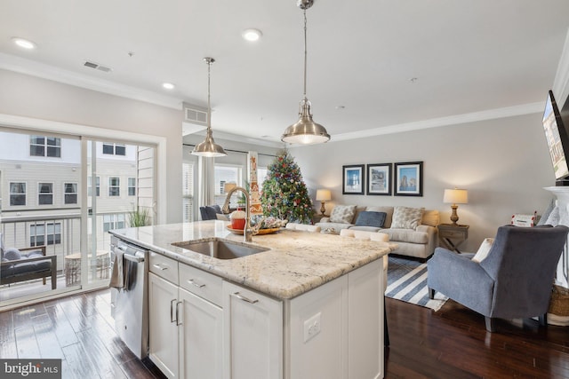 kitchen with light stone counters, stainless steel dishwasher, a kitchen island with sink, sink, and white cabinets