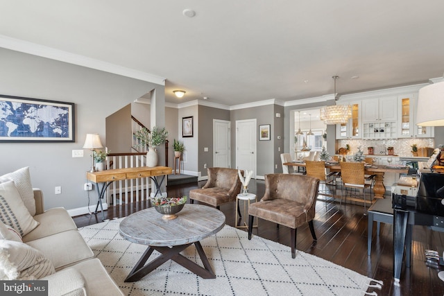 living room with light hardwood / wood-style floors, a notable chandelier, and ornamental molding