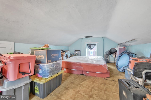 bedroom featuring lofted ceiling and a textured ceiling