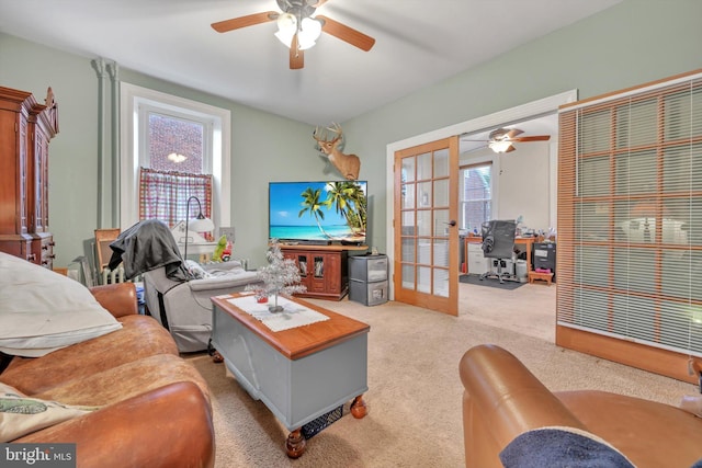 carpeted living room featuring ceiling fan and french doors