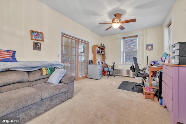 office space featuring ceiling fan, radiator heating unit, and light colored carpet