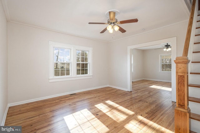 empty room with light wood-type flooring, ceiling fan, and ornamental molding