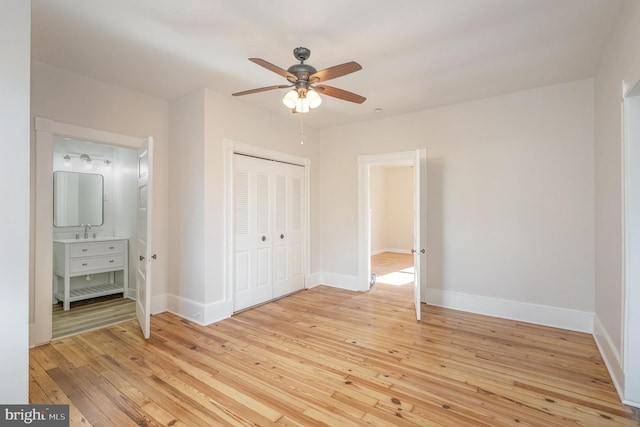 unfurnished bedroom featuring ceiling fan, light hardwood / wood-style floors, sink, and a closet