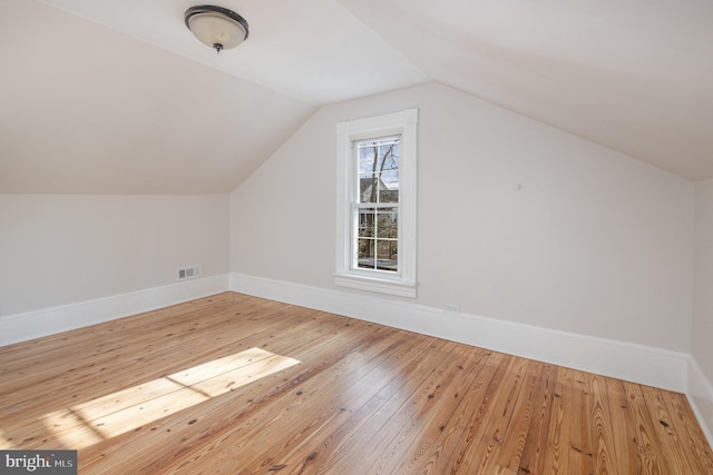 bonus room with hardwood / wood-style flooring and lofted ceiling