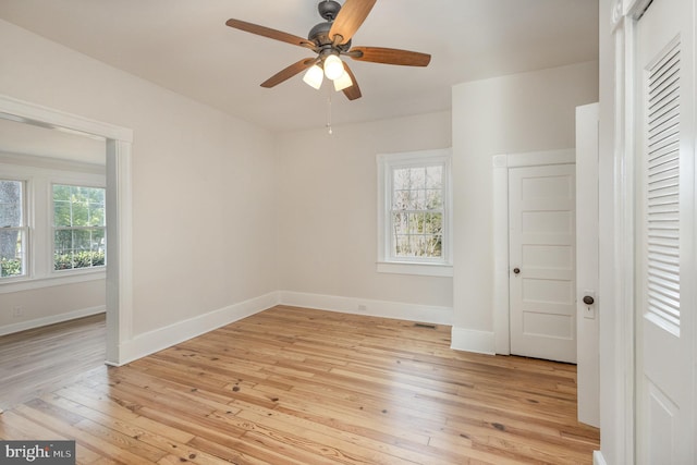 unfurnished bedroom with ceiling fan, multiple windows, and light hardwood / wood-style flooring