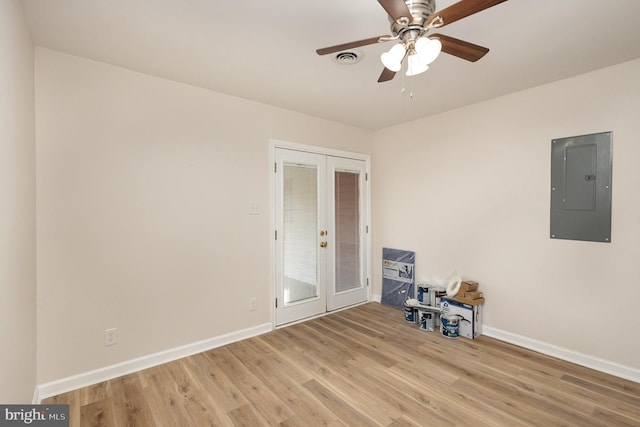 spare room with french doors, electric panel, light hardwood / wood-style flooring, and ceiling fan