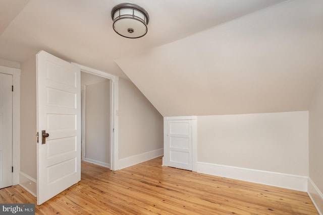 additional living space featuring light hardwood / wood-style floors and vaulted ceiling