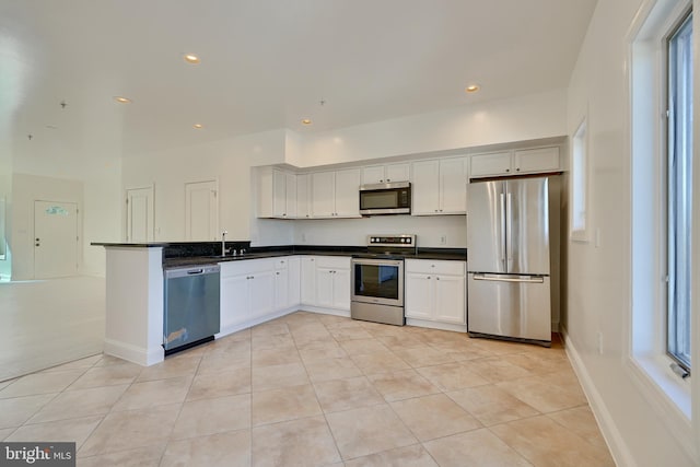 kitchen with white cabinetry, sink, stainless steel appliances, plenty of natural light, and light tile patterned floors