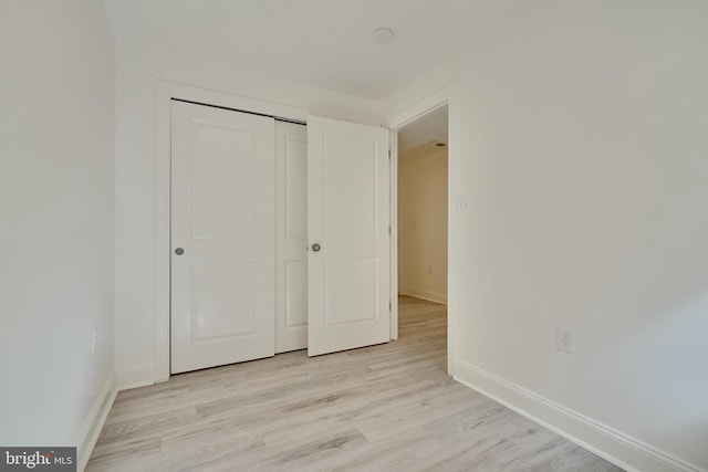 unfurnished bedroom featuring a closet and light hardwood / wood-style flooring