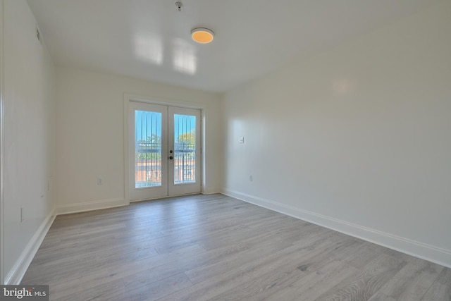 empty room with light hardwood / wood-style flooring and french doors