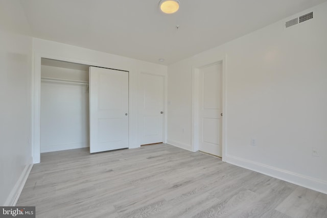 unfurnished bedroom featuring a closet and light hardwood / wood-style floors