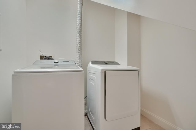 washroom featuring light tile patterned floors and washer and clothes dryer