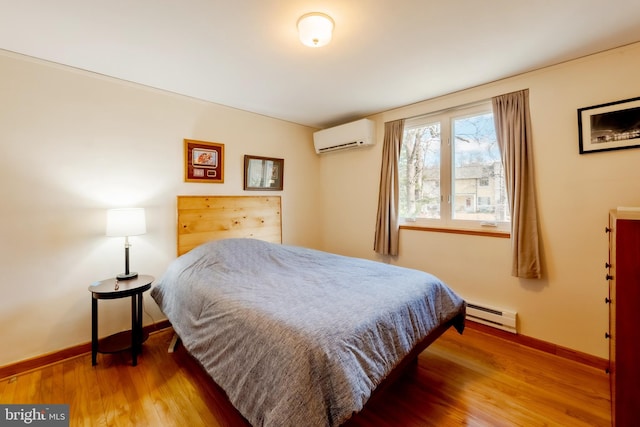 bedroom with wood-type flooring, an AC wall unit, and a baseboard radiator