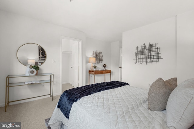 bedroom featuring a spacious closet and light carpet