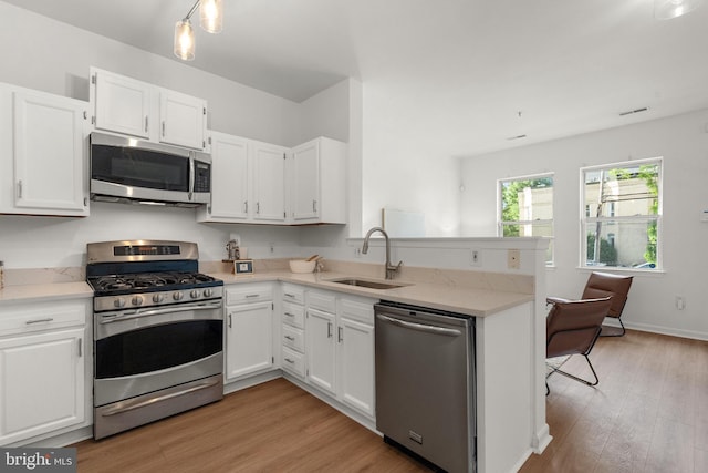 kitchen featuring white cabinets, light wood-type flooring, sink, and appliances with stainless steel finishes