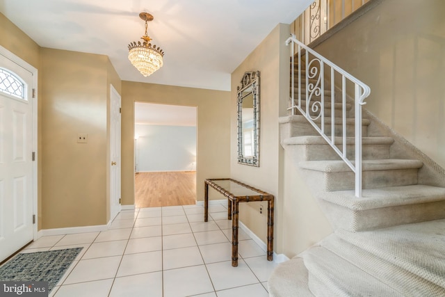 foyer entrance with light tile patterned floors and an inviting chandelier