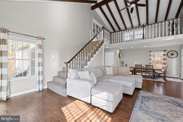 living room featuring beam ceiling, dark hardwood / wood-style floors, high vaulted ceiling, and ceiling fan