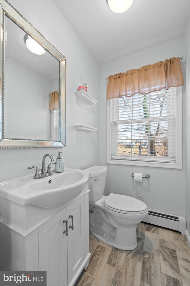 bathroom with vanity, a baseboard radiator, and toilet