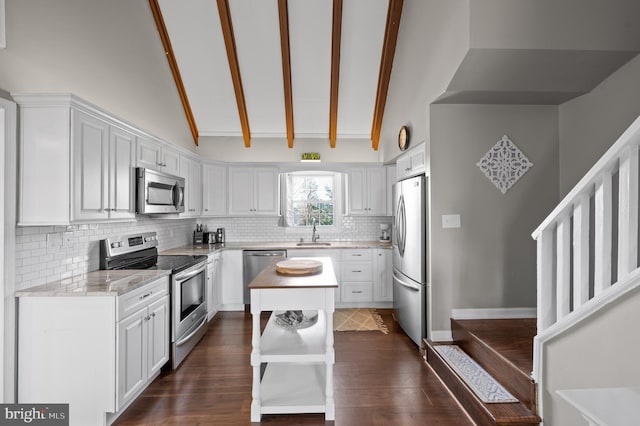 kitchen featuring high vaulted ceiling, white cabinets, sink, appliances with stainless steel finishes, and beam ceiling