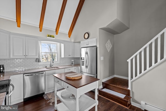 kitchen with backsplash, a baseboard heating unit, beam ceiling, white cabinetry, and stainless steel appliances