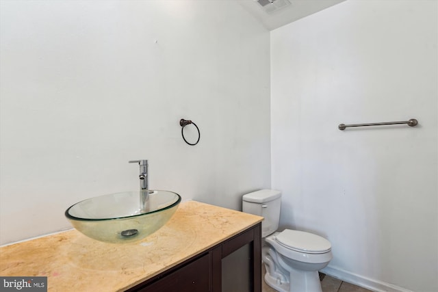 bathroom with tile patterned flooring, vanity, and toilet