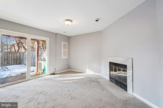 unfurnished living room featuring a high end fireplace and light carpet