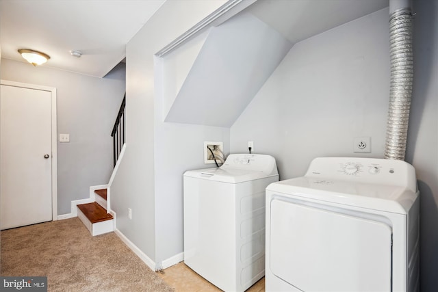 clothes washing area featuring washer and clothes dryer and light colored carpet