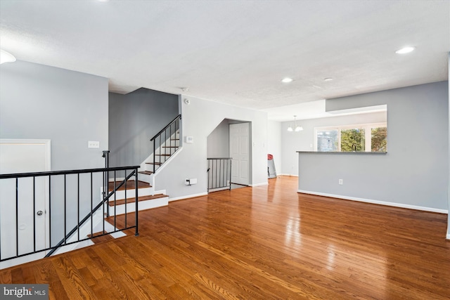 empty room featuring a chandelier and hardwood / wood-style flooring