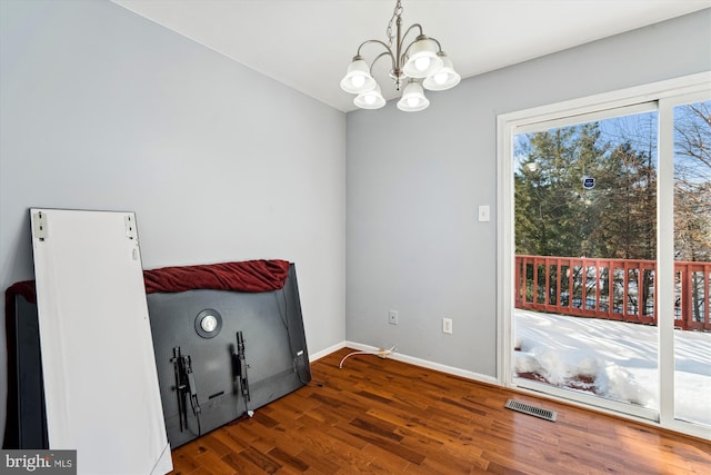 unfurnished room featuring dark hardwood / wood-style floors and a notable chandelier