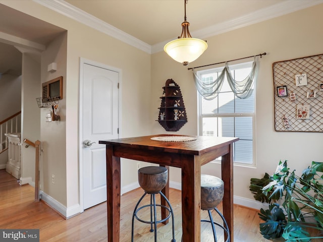 dining area featuring light hardwood / wood-style floors and ornamental molding