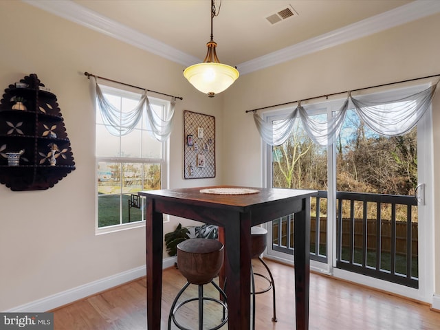 dining room with hardwood / wood-style flooring and crown molding