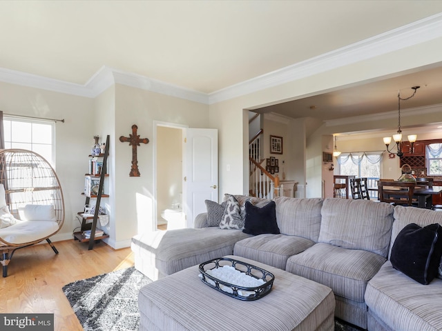 living room featuring light hardwood / wood-style floors, crown molding, and a chandelier