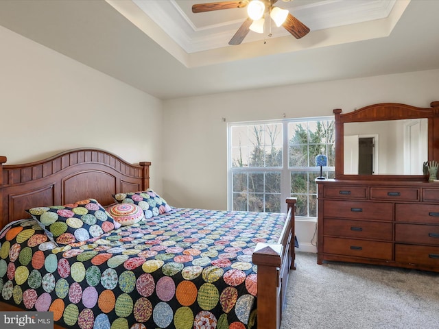 bedroom with ceiling fan, a raised ceiling, light colored carpet, and crown molding