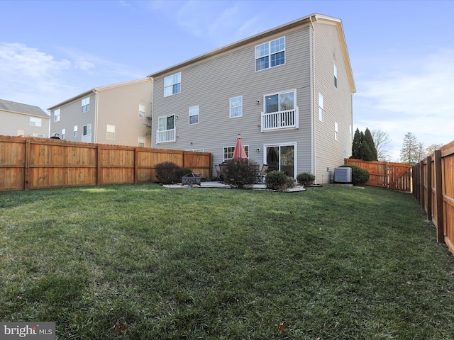 back of house with central air condition unit and a lawn