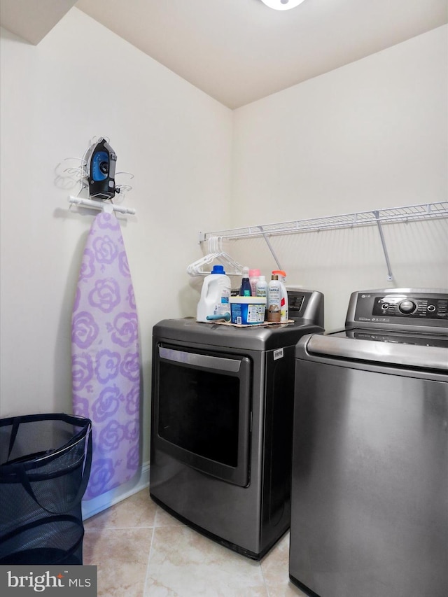 laundry room with light tile patterned flooring and washer and dryer