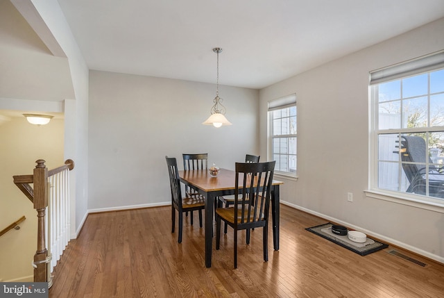 dining space with wood-type flooring