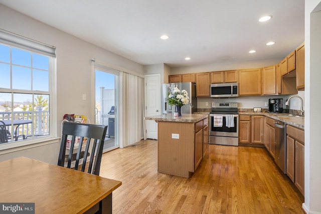 kitchen featuring a kitchen island, sink, light wood-type flooring, and stainless steel appliances