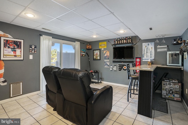 tiled living room featuring a drop ceiling